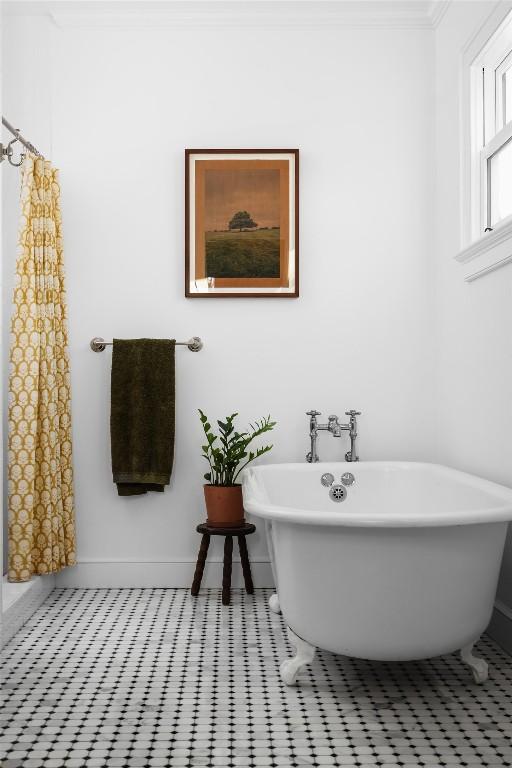 bathroom featuring a soaking tub and baseboards