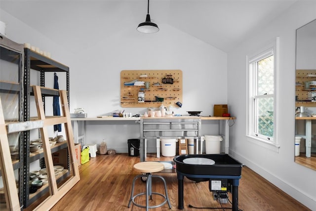 dining room featuring baseboards, vaulted ceiling, and wood finished floors