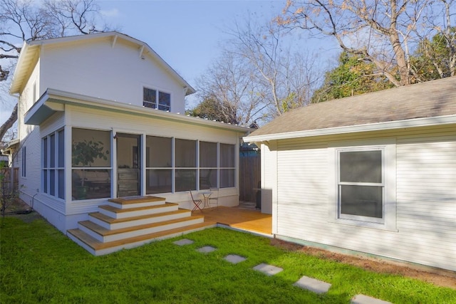 rear view of property featuring a sunroom and a lawn