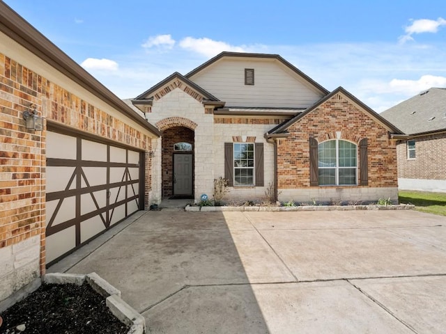 view of front of home featuring a garage, brick siding, and driveway