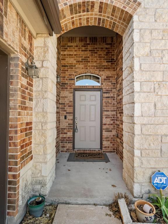 view of exterior entry featuring brick siding