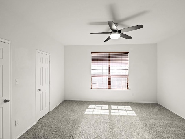 spare room featuring carpet flooring and a ceiling fan