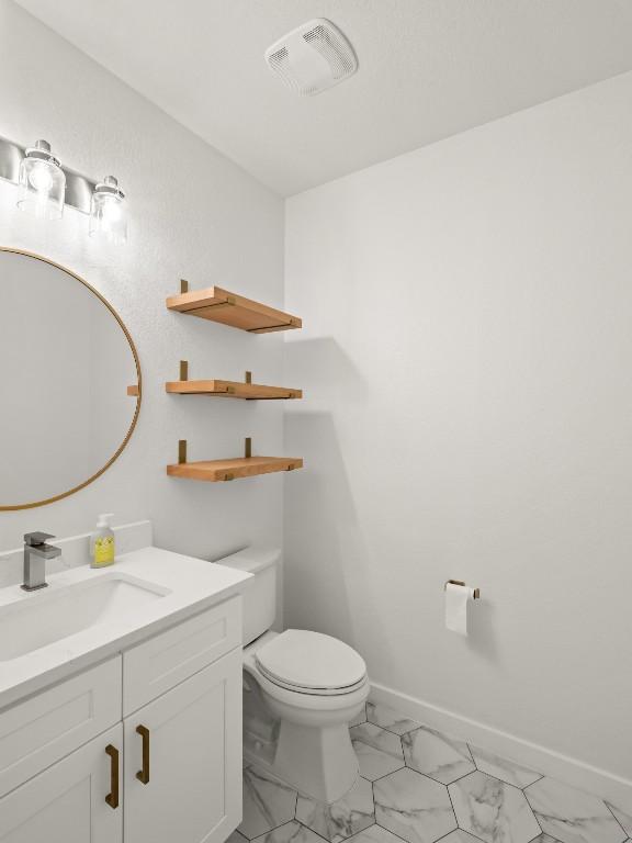 bathroom featuring marble finish floor, visible vents, toilet, vanity, and baseboards