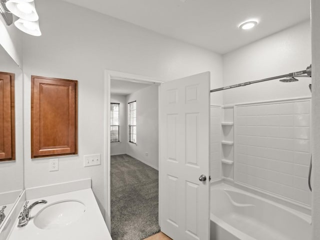 bathroom with shower / bathing tub combination, vanity, and baseboards