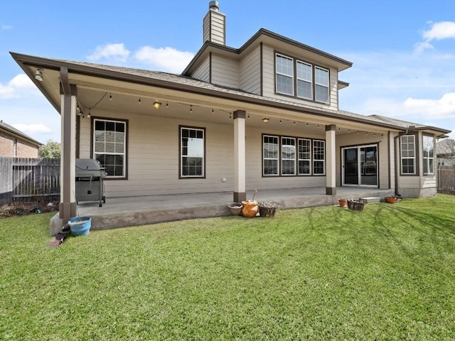 rear view of house with a yard, a patio area, and fence