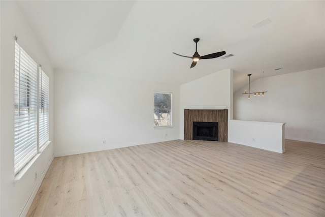 unfurnished living room with lofted ceiling, light wood-style flooring, a fireplace, and visible vents