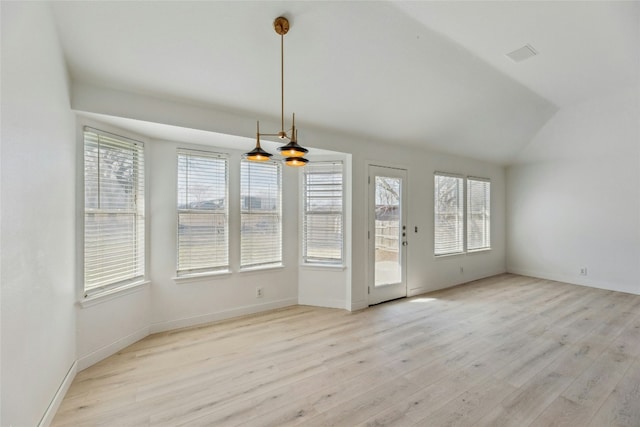 interior space featuring lofted ceiling, light wood-style floors, and baseboards