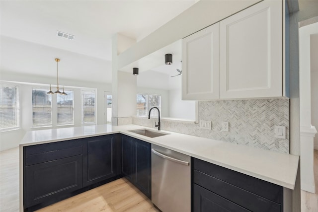 kitchen featuring dishwasher, a sink, visible vents, and white cabinets