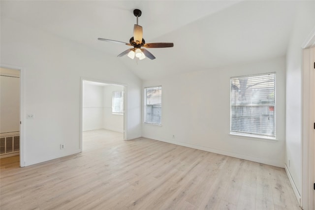 empty room with lofted ceiling, visible vents, ceiling fan, light wood-type flooring, and baseboards