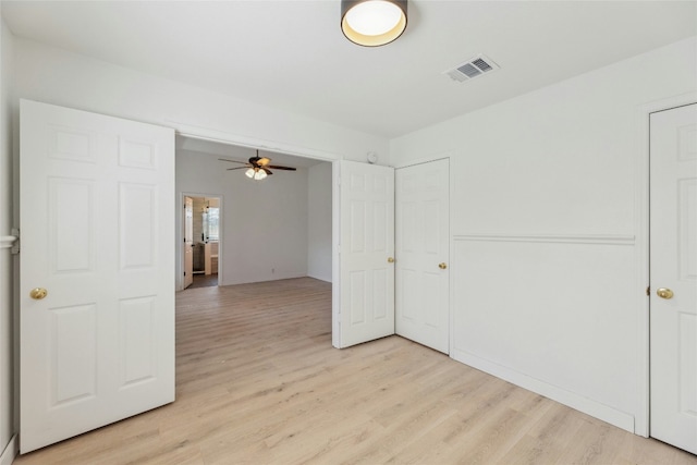 spare room featuring ceiling fan, light wood-type flooring, and visible vents