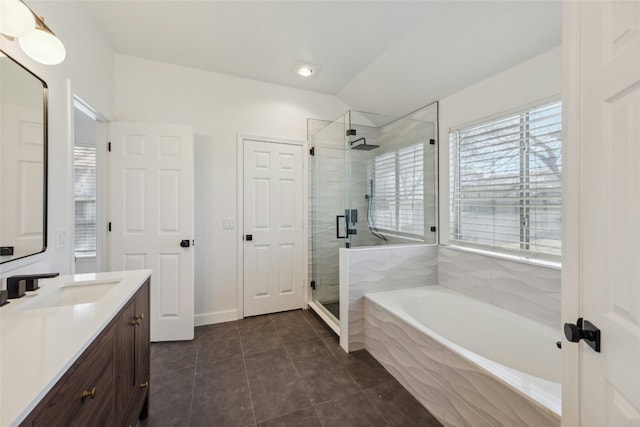 full bathroom with a stall shower, vaulted ceiling, vanity, a bath, and tile patterned floors