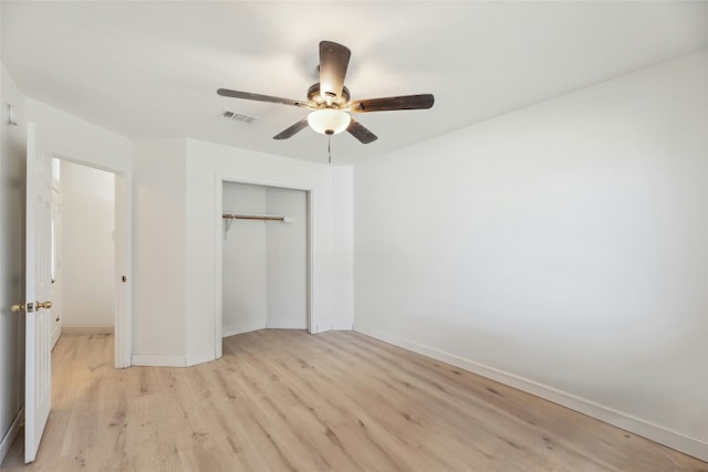 unfurnished bedroom with light wood-style flooring, visible vents, baseboards, a ceiling fan, and a closet