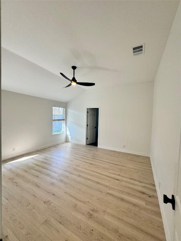 203 Little Lake Rd, Hutto, TX 78634 - unfurnished room featuring light wood-style flooring, vaulted ceiling, and a ceiling fan
