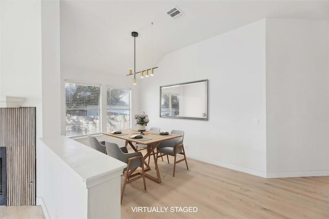 203 Little Lake Rd, Hutto, TX 78634 - dining room featuring light wood-type flooring, vaulted ceiling, and a chandelier