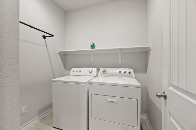 laundry room with laundry area, washer and clothes dryer, and baseboards