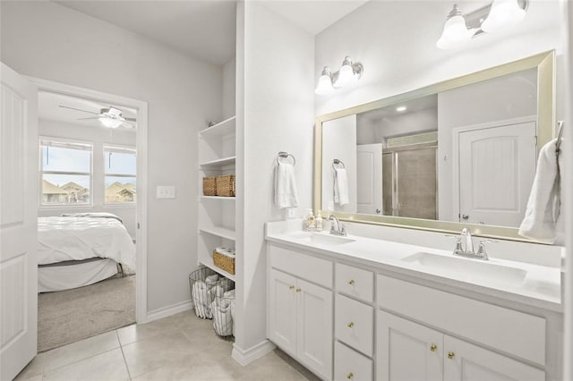 ensuite bathroom featuring double vanity, a sink, a ceiling fan, and a shower stall