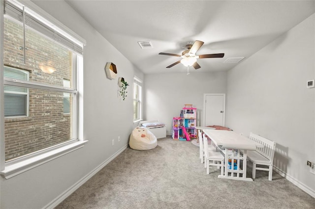 rec room with a ceiling fan, carpet, visible vents, and baseboards