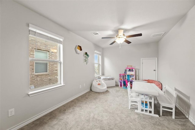 recreation room featuring baseboards, visible vents, ceiling fan, and carpet flooring