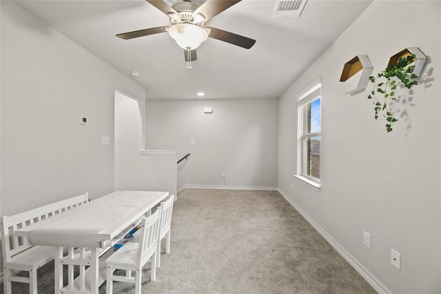 dining space featuring light carpet, visible vents, and baseboards