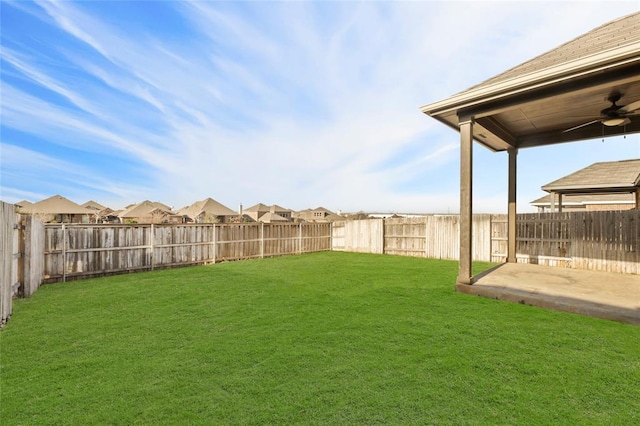 view of yard with ceiling fan and a fenced backyard