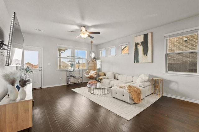 living area featuring baseboards, visible vents, ceiling fan, and wood finished floors