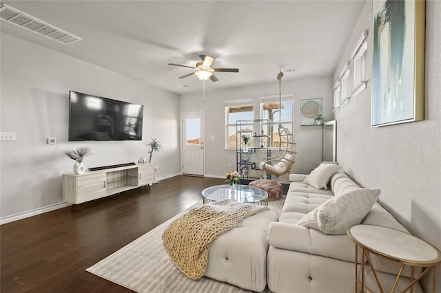 living area with visible vents, ceiling fan, baseboards, and wood finished floors