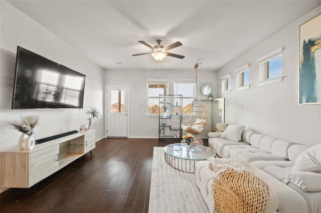 living area with dark wood-style floors, a ceiling fan, and baseboards