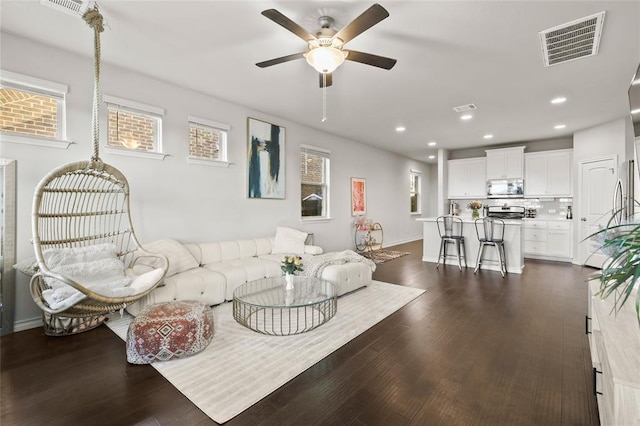 living room with a ceiling fan, dark wood finished floors, visible vents, and recessed lighting