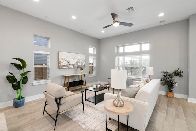 living area with recessed lighting, visible vents, baseboards, and wood finished floors