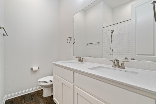 full bathroom with toilet, wood finished floors, a sink, double vanity, and walk in shower