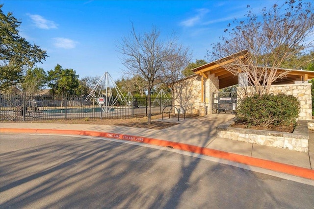 view of home's community with community basketball court, a gate, and fence