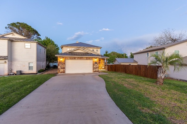 view of front of property with concrete driveway, metal roof, a standing seam roof, fence, and a front yard