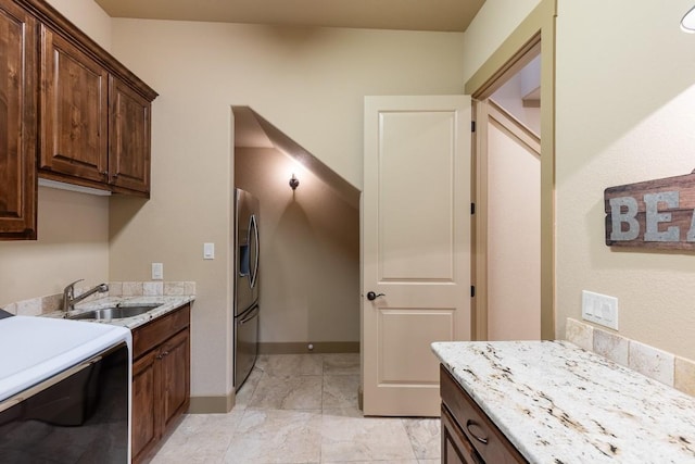 kitchen featuring baseboards, stove, dark brown cabinets, stainless steel refrigerator with ice dispenser, and a sink