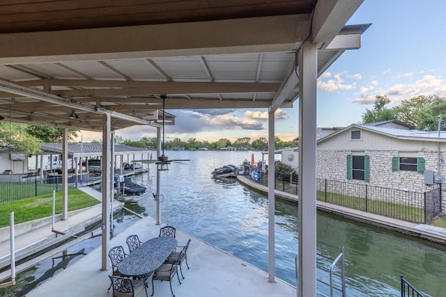 view of dock with a water view, boat lift, and fence