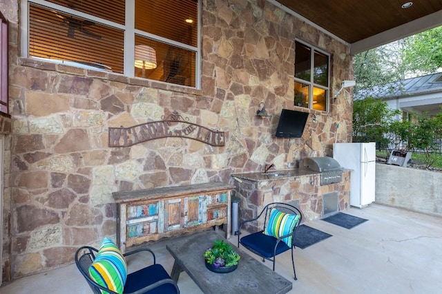 view of patio / terrace with a sink, exterior kitchen, area for grilling, and a fireplace