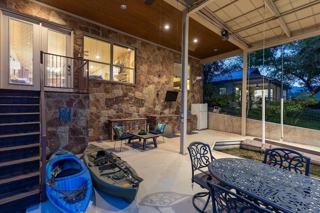 view of patio with an outdoor stone fireplace and outdoor dining area