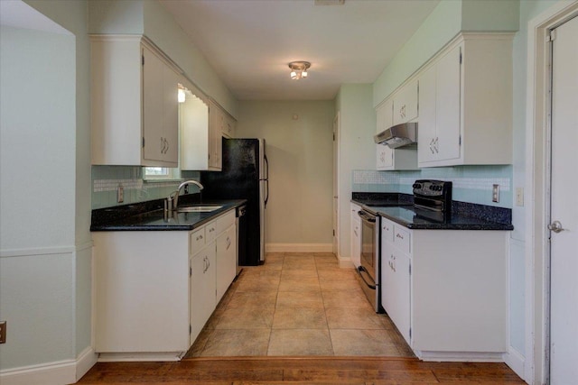 kitchen featuring electric range, decorative backsplash, under cabinet range hood, white cabinetry, and a sink