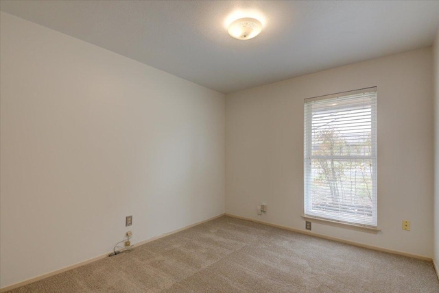 empty room with light carpet and baseboards