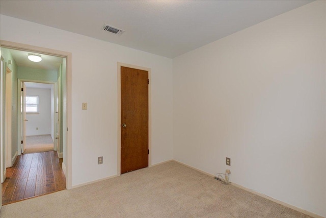 unfurnished room with carpet flooring, visible vents, and baseboards