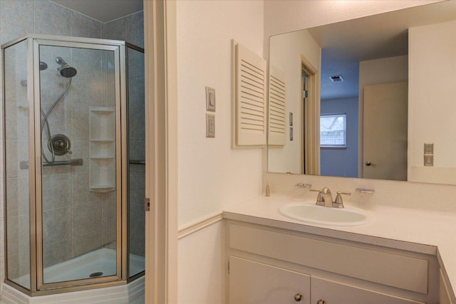 full bathroom featuring a stall shower, visible vents, and vanity