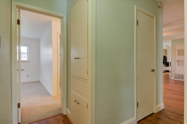 hall with wood finished floors and visible vents