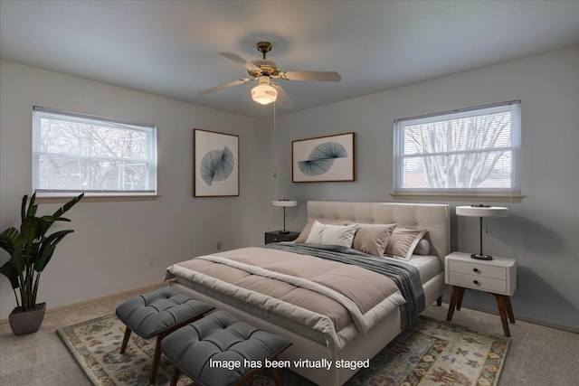 carpeted bedroom featuring ceiling fan, multiple windows, and baseboards