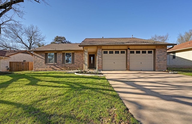 ranch-style house with concrete driveway, an attached garage, fence, a front yard, and brick siding