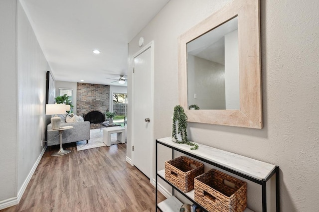 hall featuring recessed lighting, wood finished floors, and baseboards