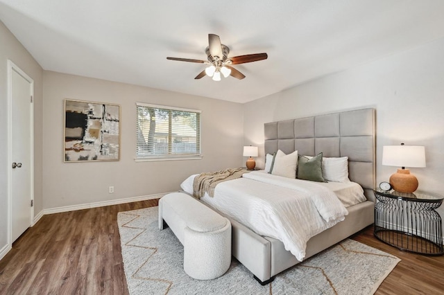 bedroom featuring ceiling fan, baseboards, and wood finished floors