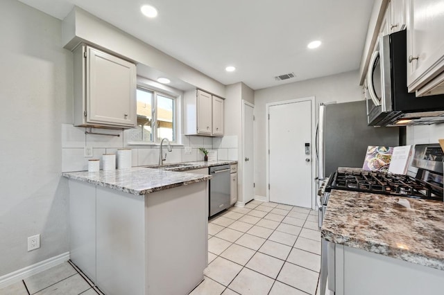 kitchen featuring light tile patterned floors, stainless steel appliances, visible vents, a sink, and a peninsula