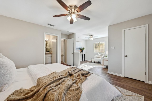 bedroom featuring visible vents, ensuite bathroom, ceiling fan, wood finished floors, and baseboards