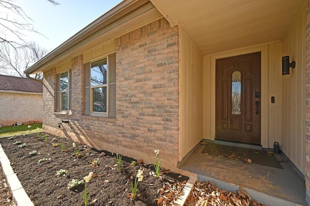 doorway to property featuring brick siding