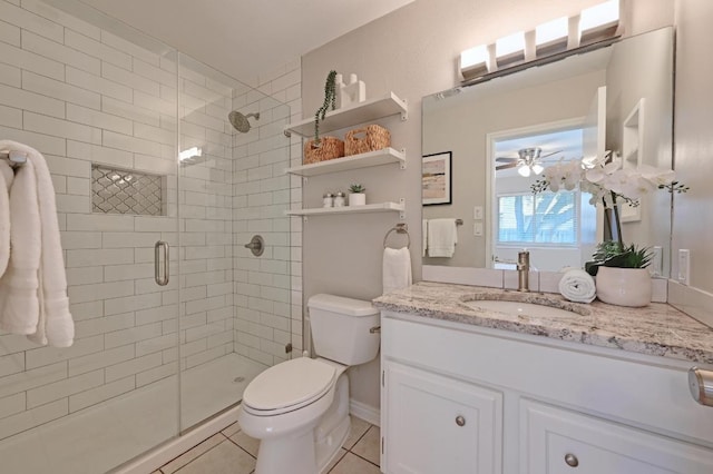 full bathroom featuring toilet, ceiling fan, tile patterned floors, vanity, and a shower stall