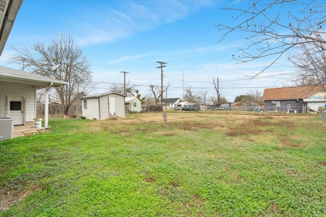 view of yard with a storage unit, fence, and an outdoor structure